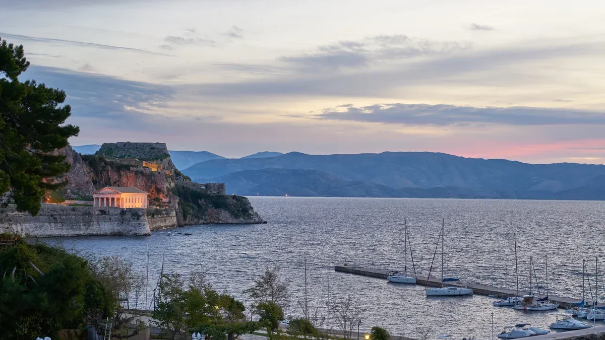 The Old Fortress of Corfu and Garitsa Bay at dusk seen on a Corfu sunset boat tour