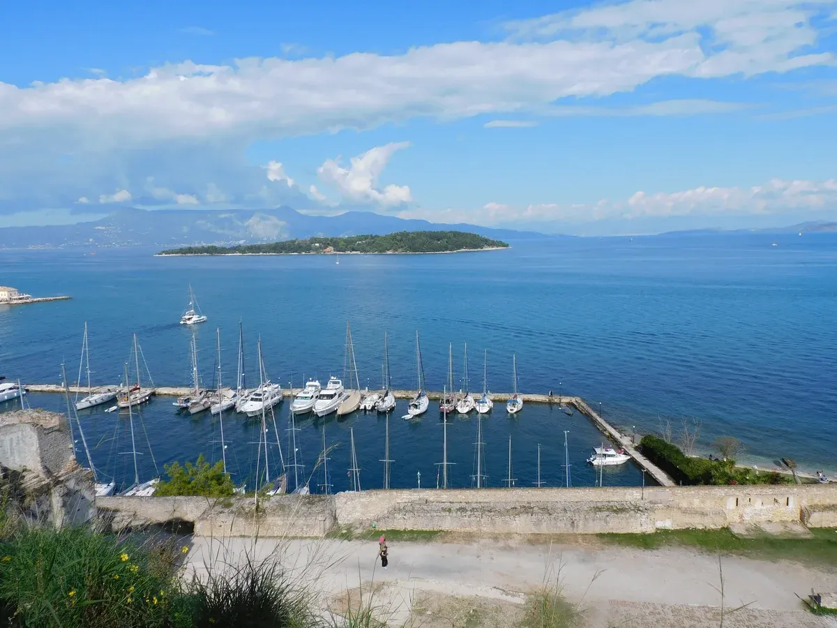 Yachts in the Corfu Town marina with Vido island behind on a private Corfu boat tour